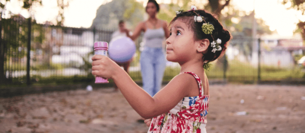 child with mom in background