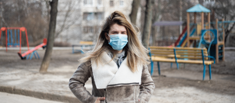 Woman with covid mask walking away from playground